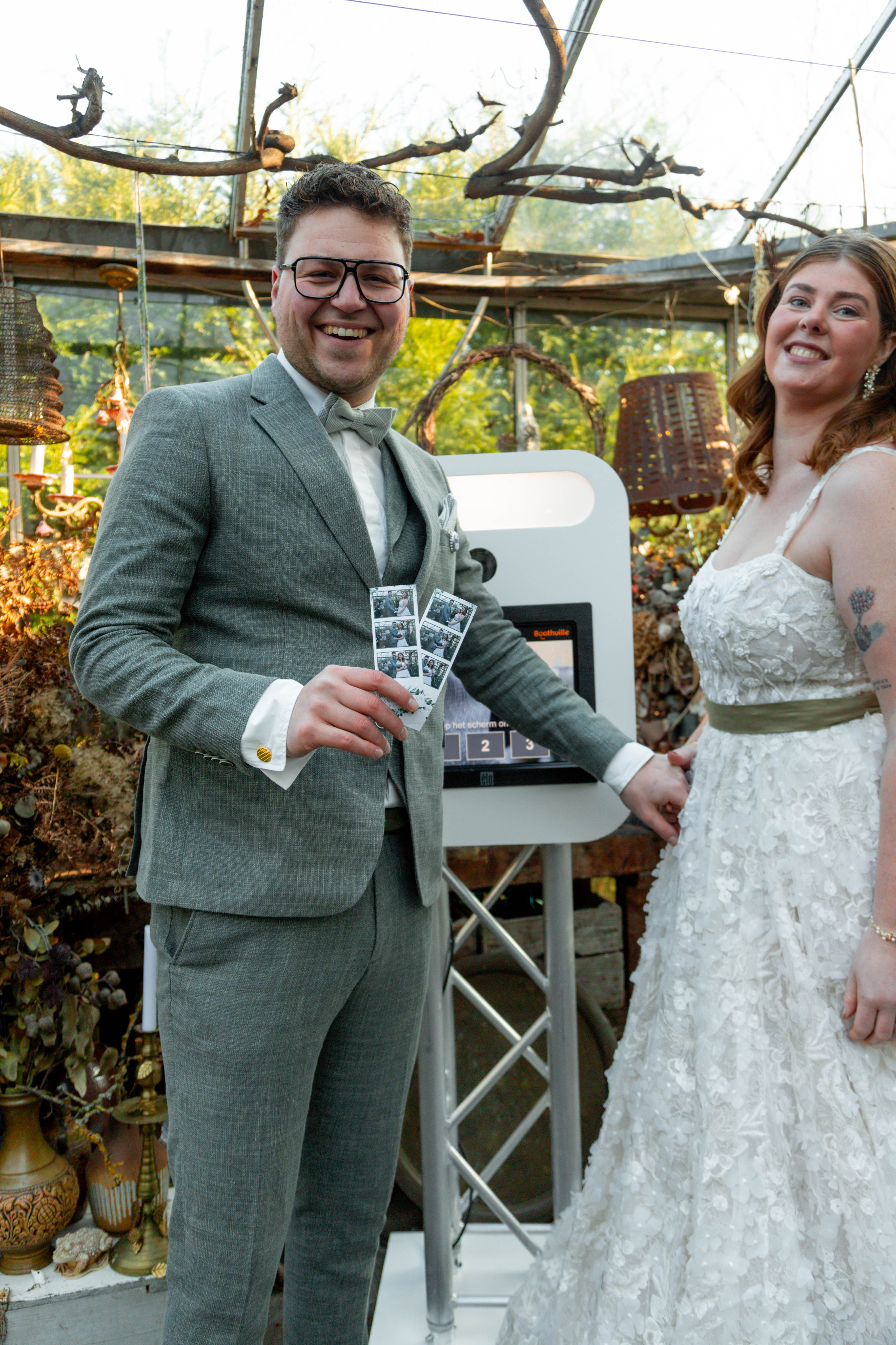 Gasten die samen de Boothville photobooth gebruiken tijdens een feest of evenement, met een geprinte fotostrip zichtbaar.