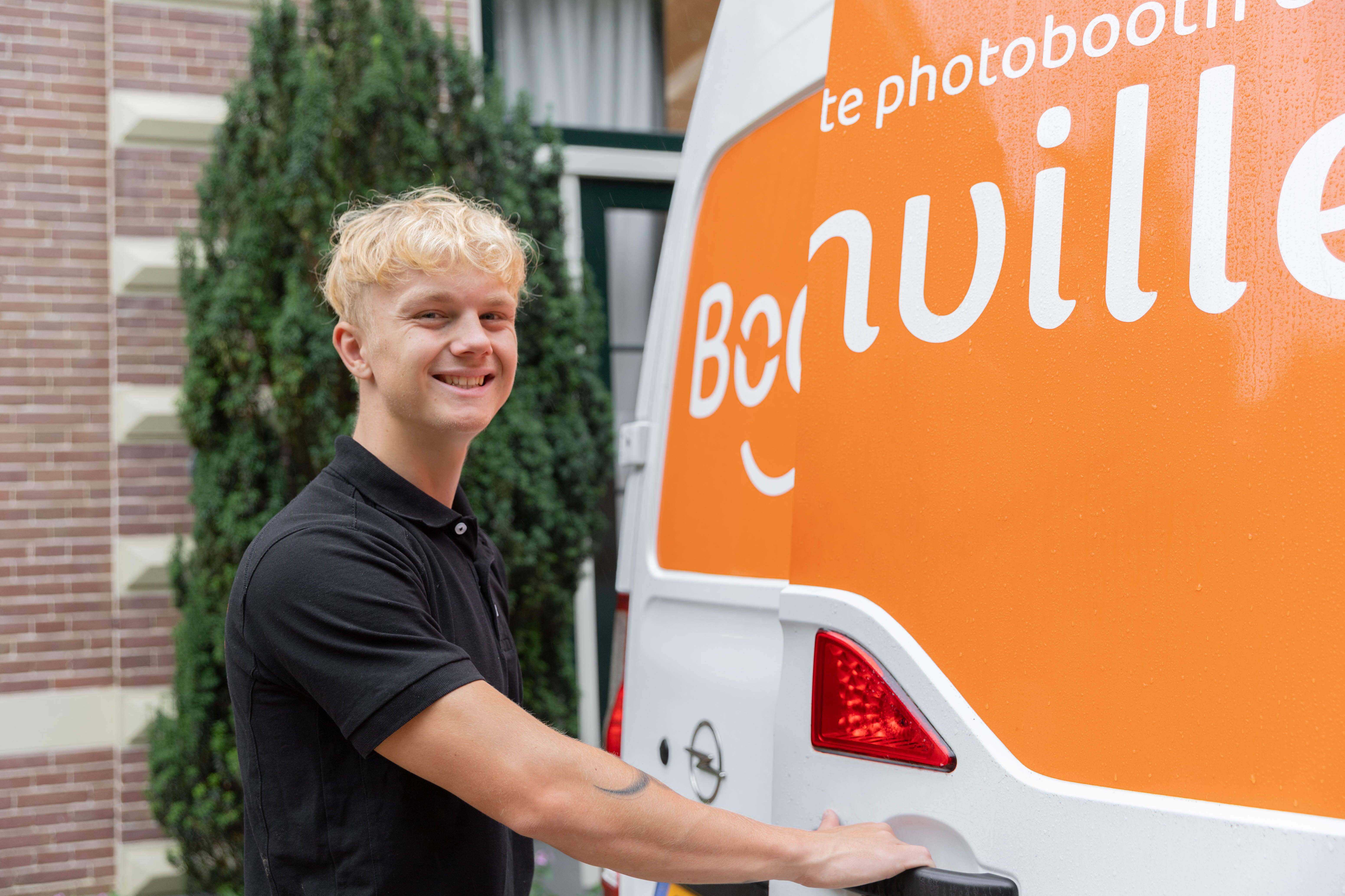 Boothville-bezorger bij een bestelbus met photoboothapparatuur.