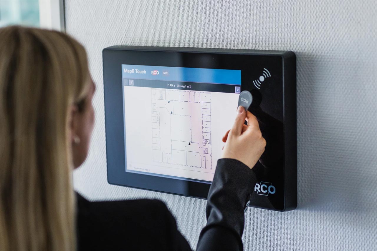 kvinne som benytter en nøkkelbrikke for adgangskontroll i boligen sin