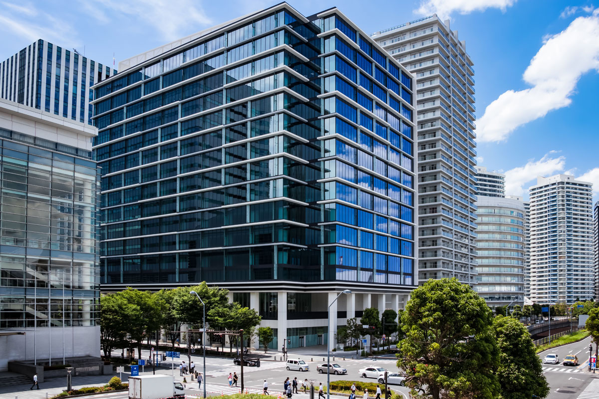 Modern glass office buildings in urban city with trees and street scene