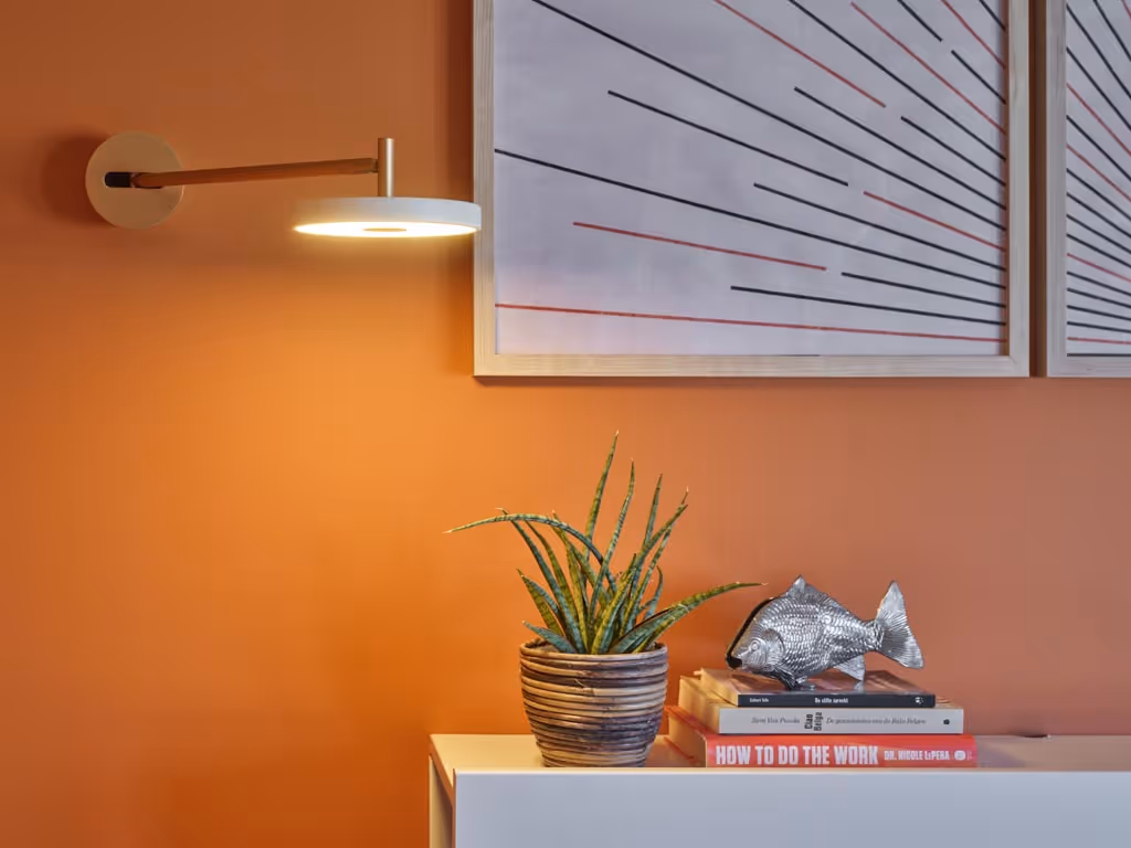 Sfeerbeeld van de gerenoveerde slaapkamer met decoratie, nachtlamp en schilderijen.