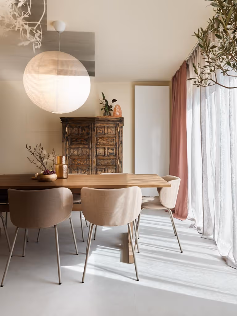 Foto van de eetruimte na de totaalrenovatie, met warme houttinten, en zacht licht interieur.