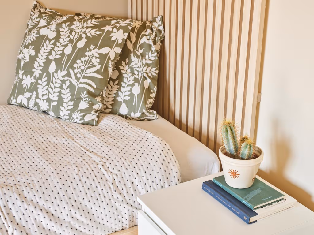 Slaapkamer na totaalrenovatie met houten accenten en rustige afwerking