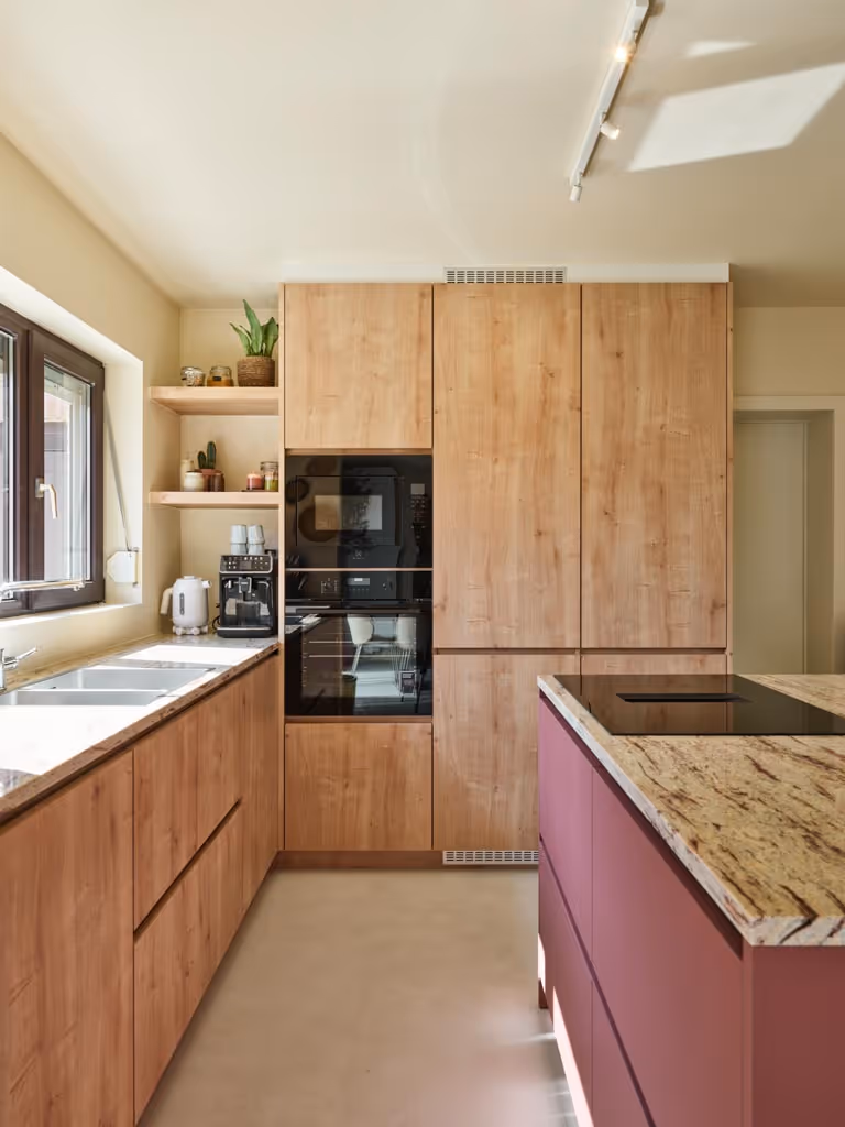 Moderne keukenrenovatie met houten maatwerk, natuurstenen werkblad en strak kookeiland