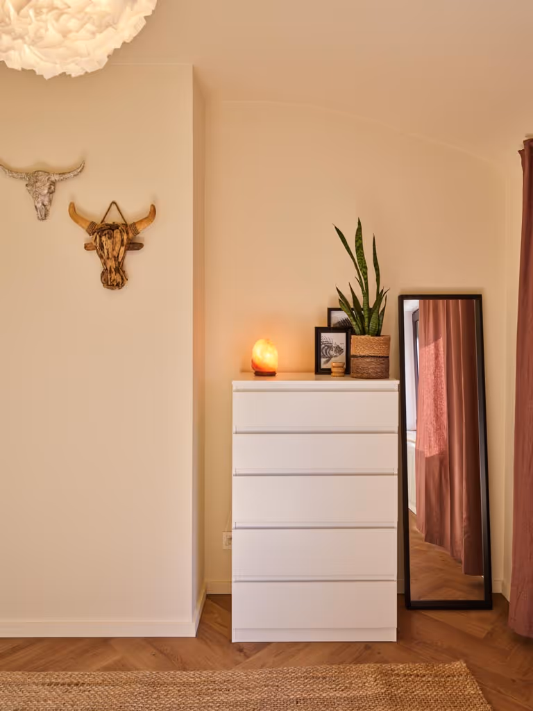 Slaapkamer na totaalrenovatie met houten vloer en rustige afwerking