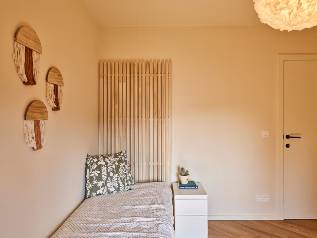 Slaapkamer na totaalrenovatie met houten accenten en rustige afwerking