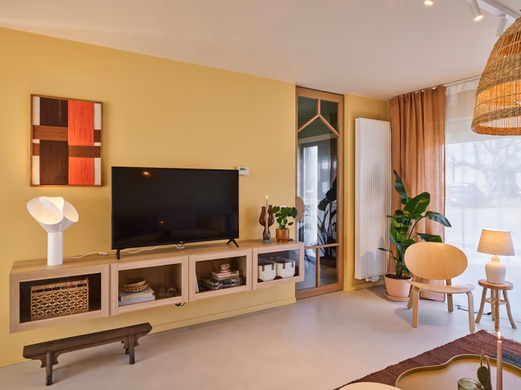 Leefruimte na totaalrenovatie met maatwerk tv-meubel en warme afwerking