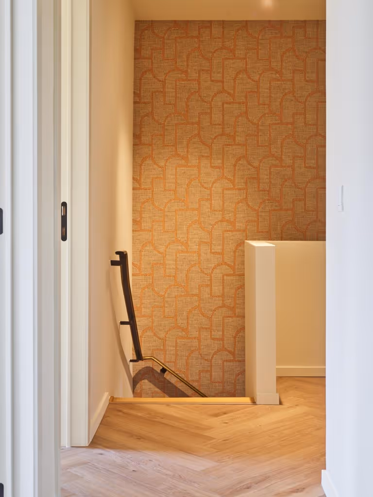 Foto van de nachthal na de totaalrenovatie met visgraat parket en de trap naar de benedenverdieping.