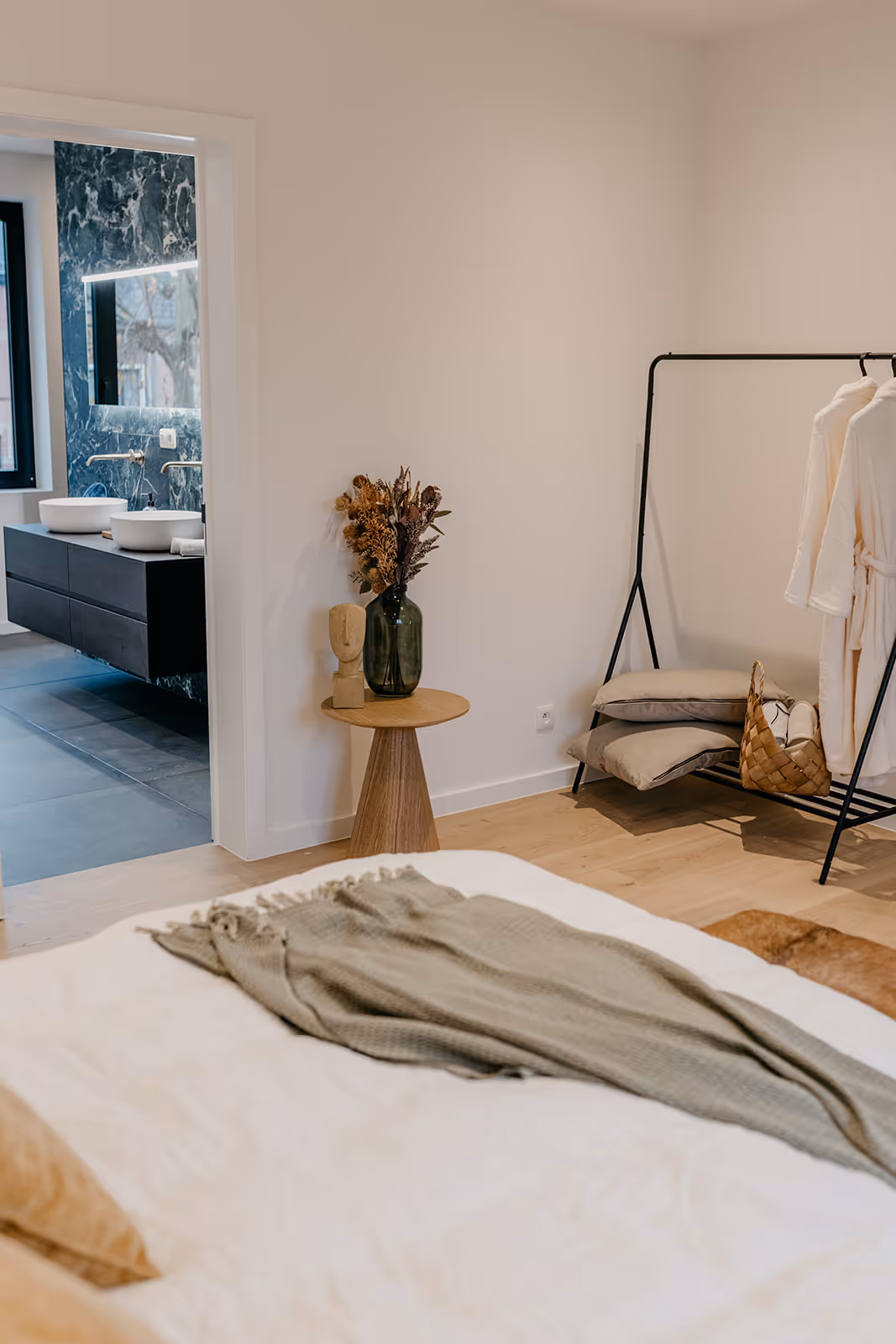 Slaapkamer na totaalrenovatie gekeken van het bed kijkend naar de gerenoveerde badkamer.