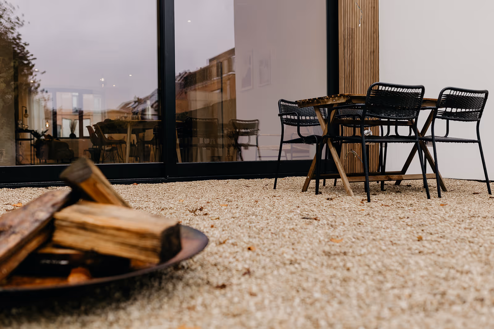 Achtergevel met nieuw terras na totaalrenovatie, met op de achtergrond de gerenoveerde woning.