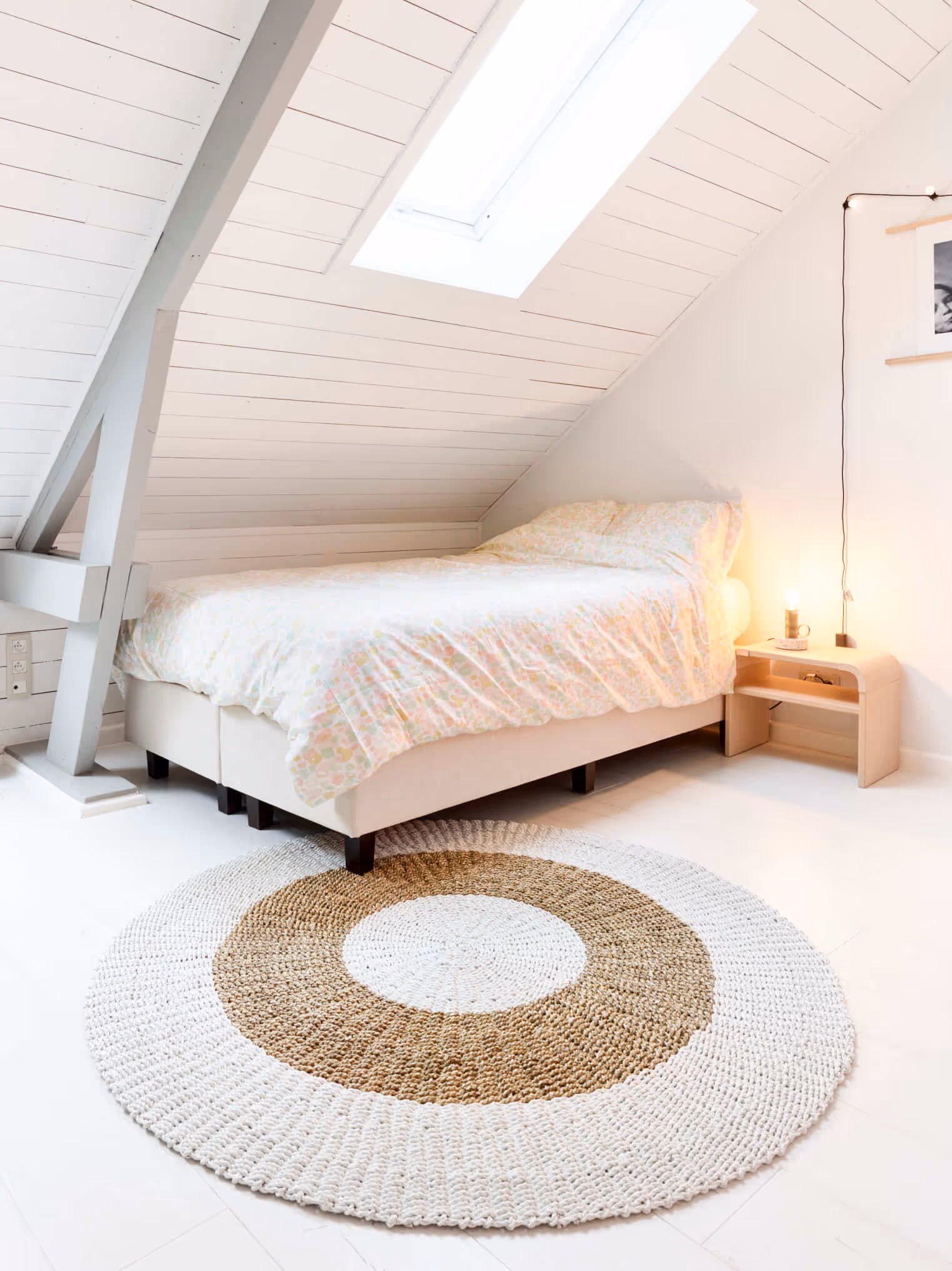 Slaapkamer na totaalrenovatie met éénpersoonsbed, schuine wand, nieuwe velux en houten spant.