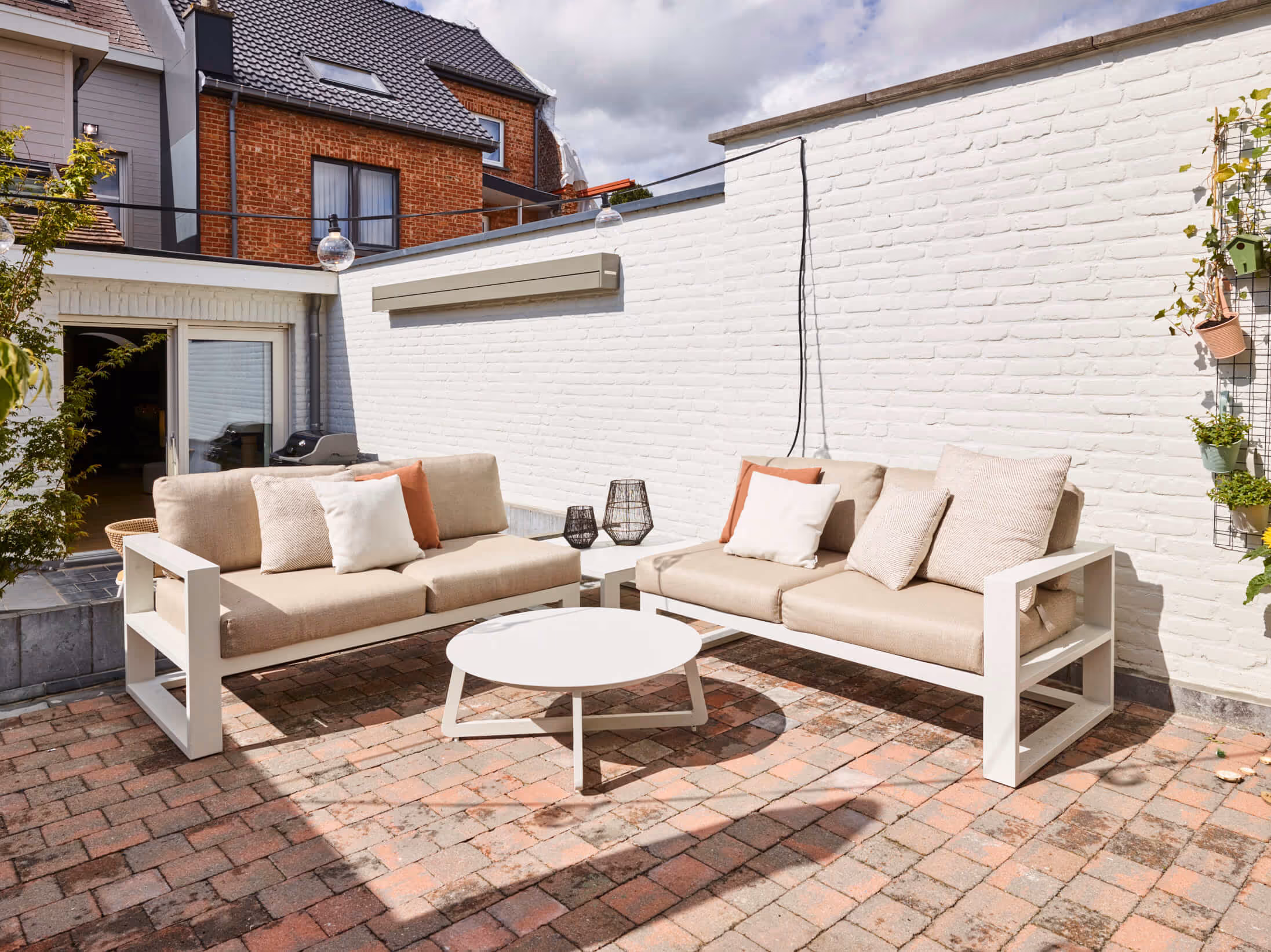 Binnenkoer van gerenoveerde woning met buitenmeubelen.