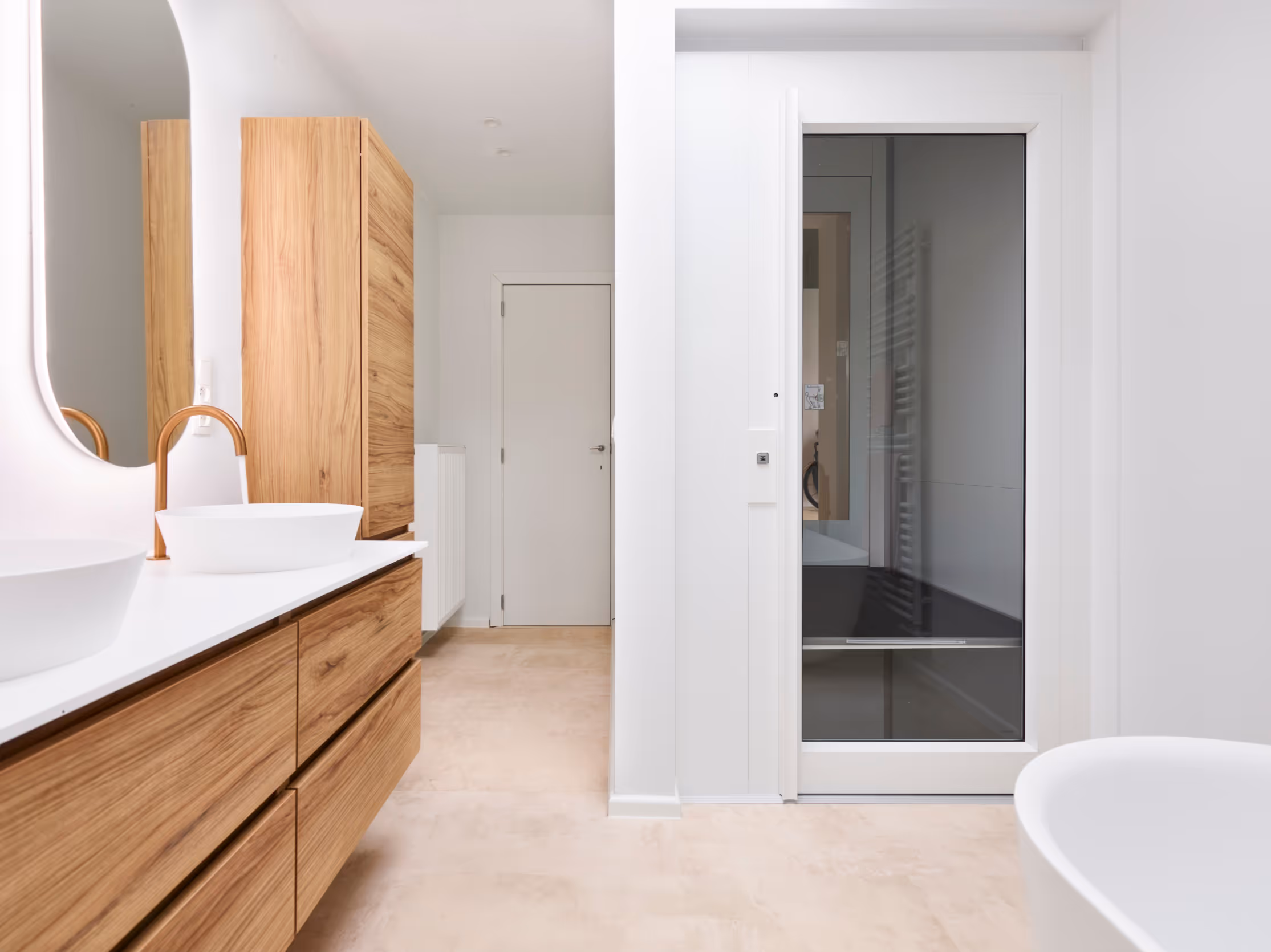 Badkamer na totaalrenovatie met frisse kleuren, houten meubels en een lift voor rolstoelgebruikers.