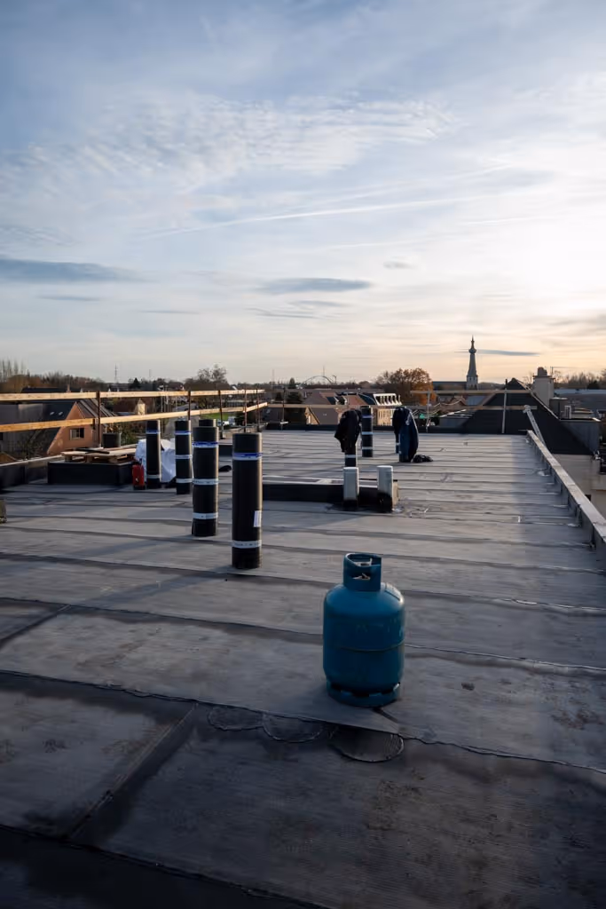 Plat dak met nieuwe roofing, dakrandbeveiliging en de horizon op de achtergrond.