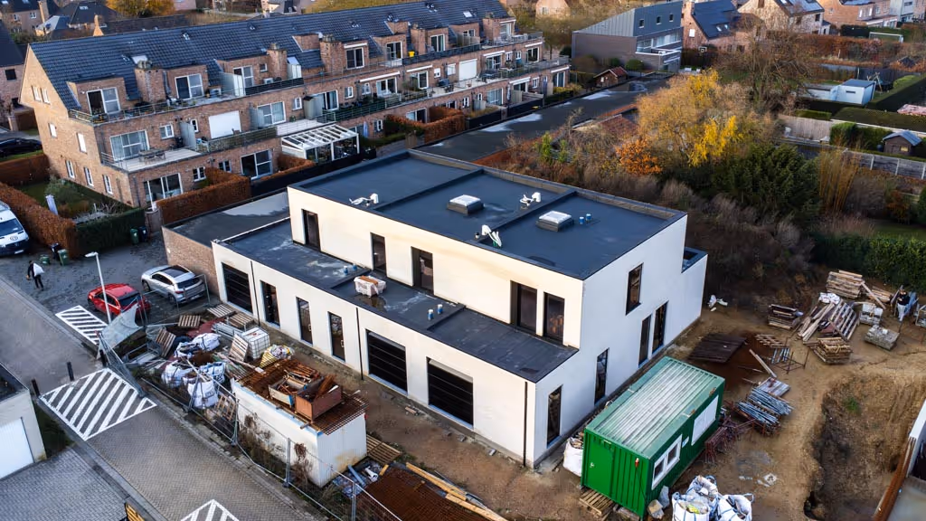 Luchtfoto van de afgewerkte woningen die voorzien zijn van nieuwe roofing, lichtkoepels en dakranden.