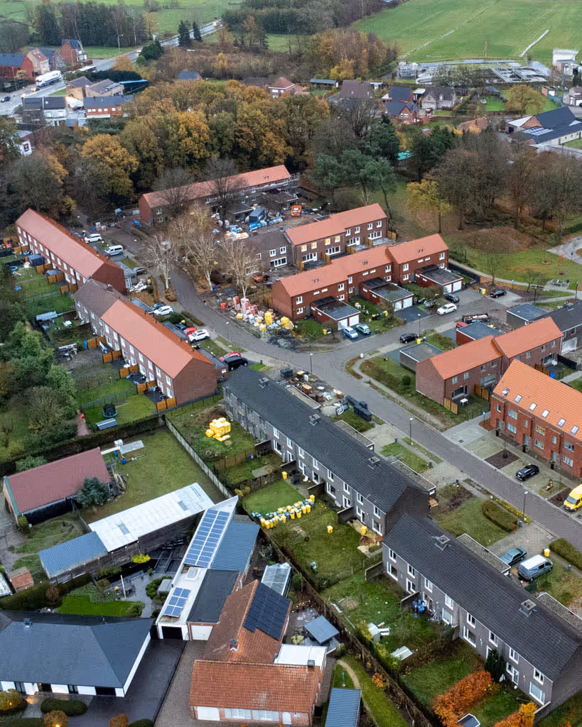Luchtfoto van woonwijk waar we de daken gerenoveerd hebben en voorzien van nieuwe dakpannen.
