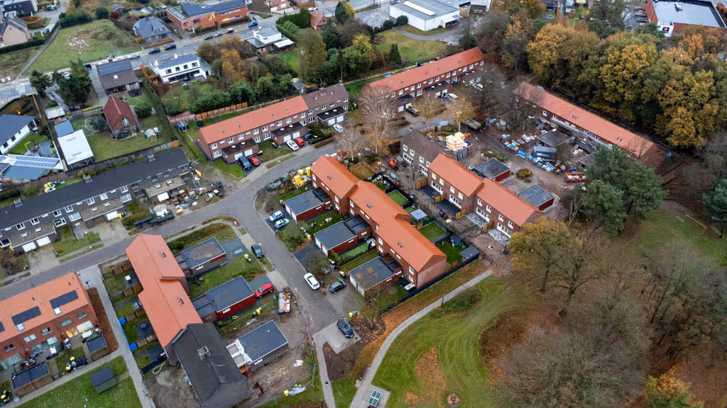 Luchtfoto van woonwijk waar we de daken gerenoveerd hebben en voorzien van nieuwe dakpannen.