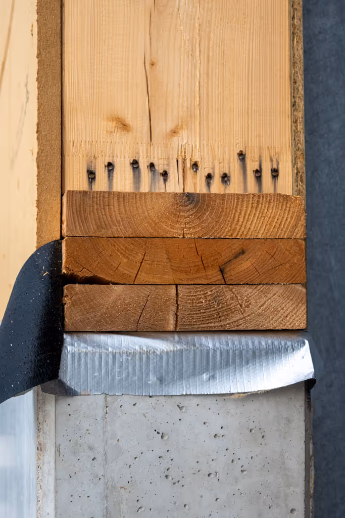 Detailfoto van de aansluiting met de betonnen plint en de houtskeletwand.