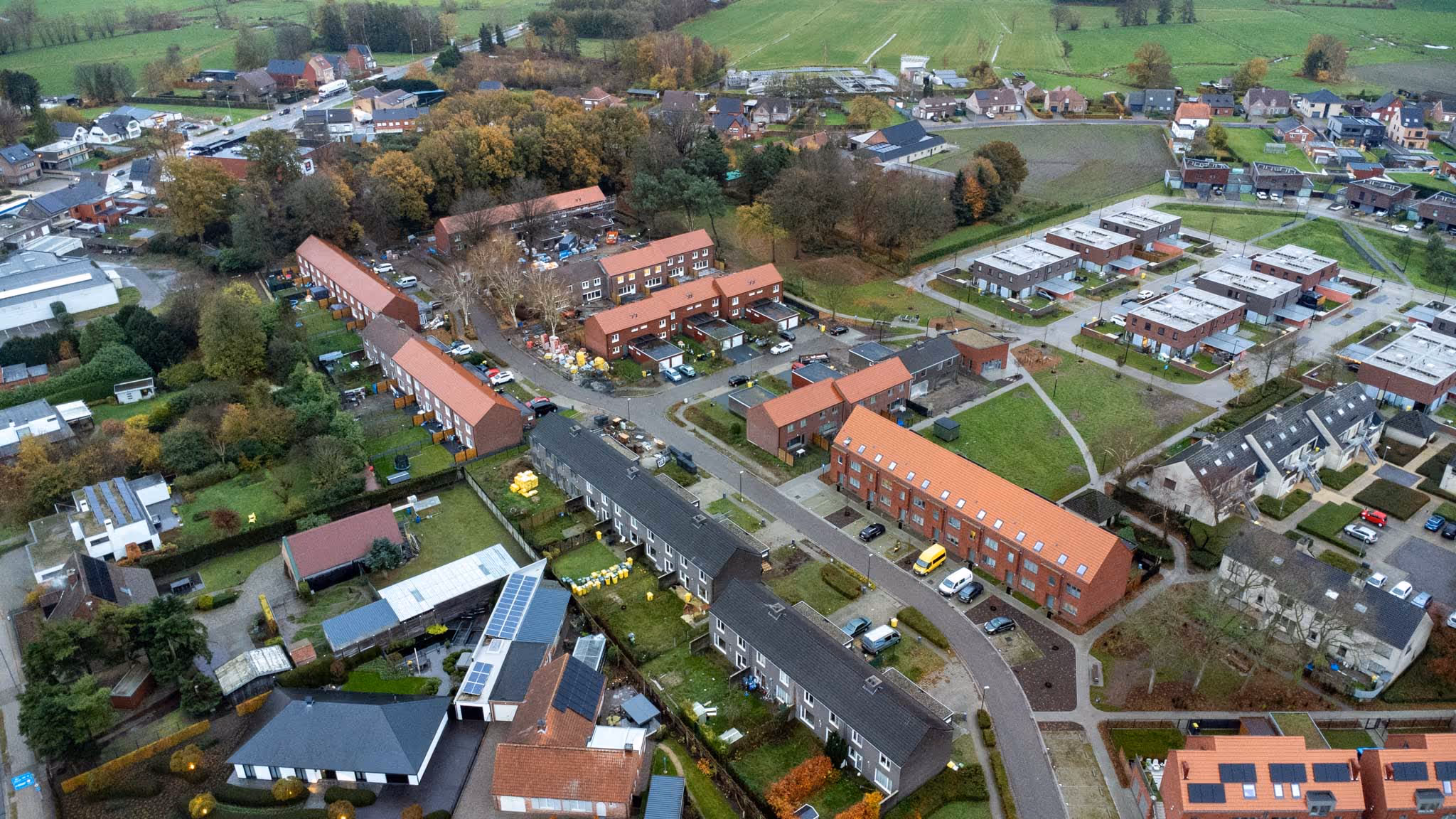 Luchtfoto van gerenoveerde woonwijk met rode en zwarte daken.