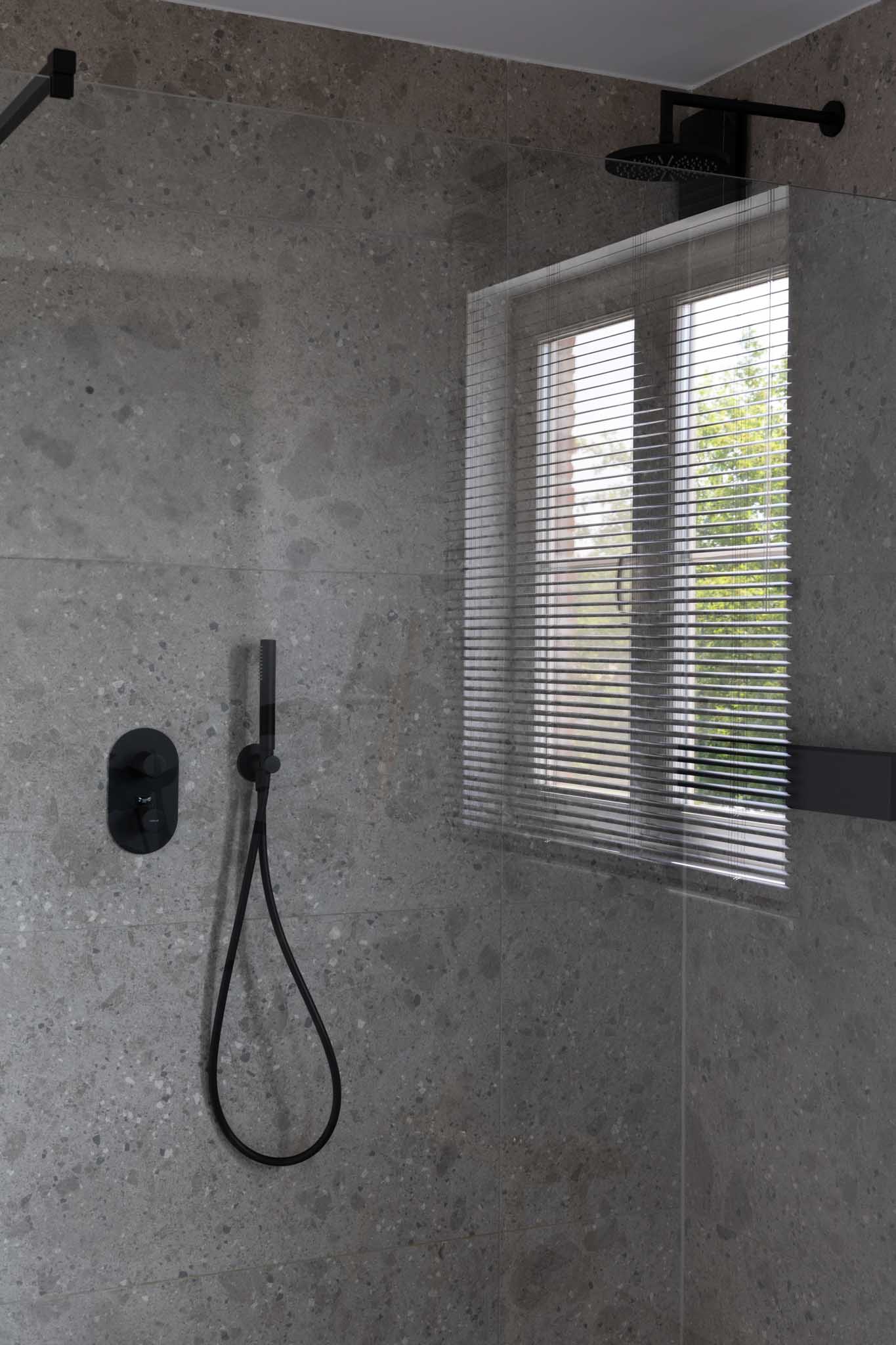 Moderne badkamer na renovatie met glazen wand die door kijkt in de inloopdouche.