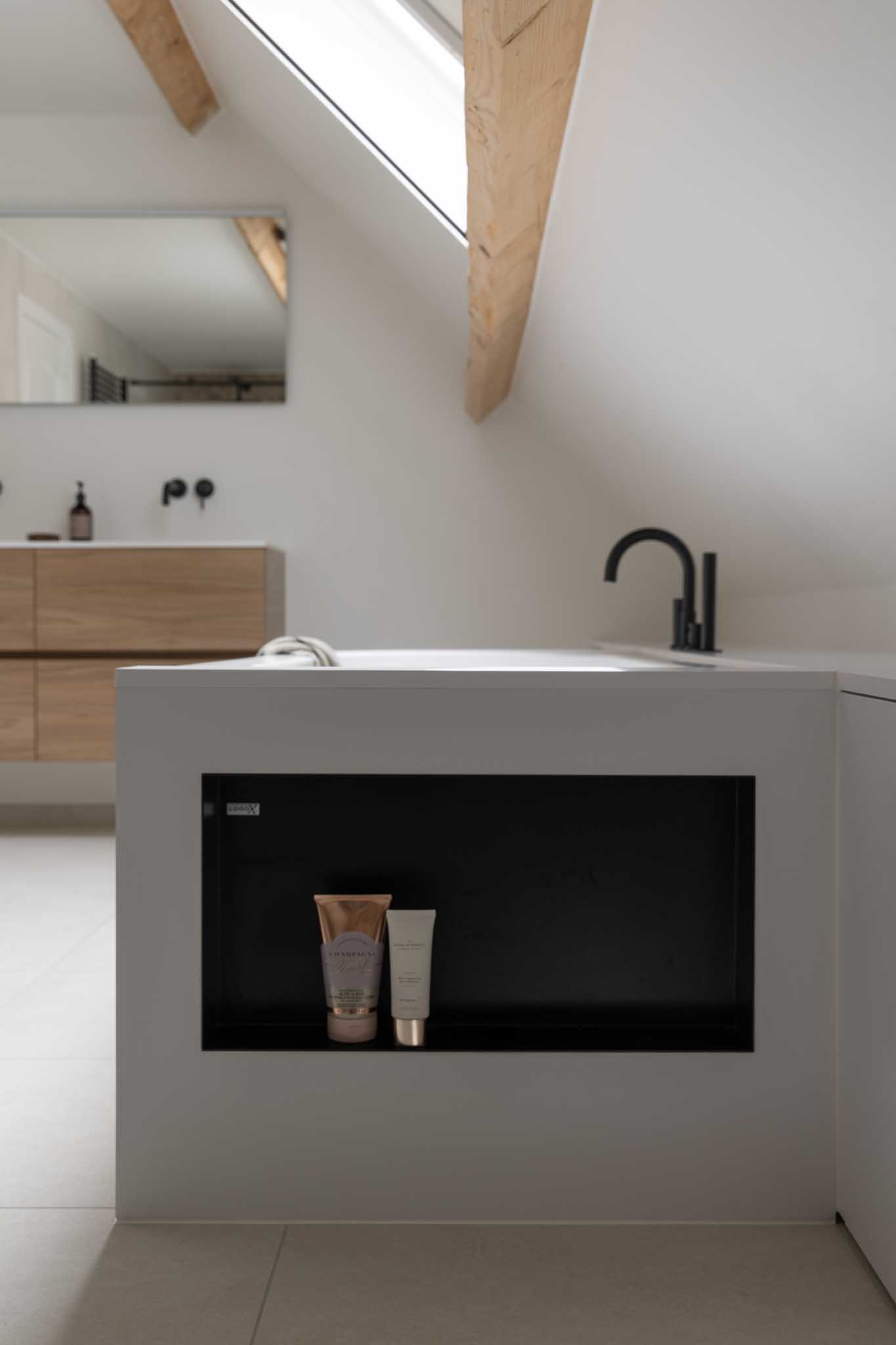 Moderne badkamerrenovatie met als detail de inbouwnis achter het back-to-wall bad.