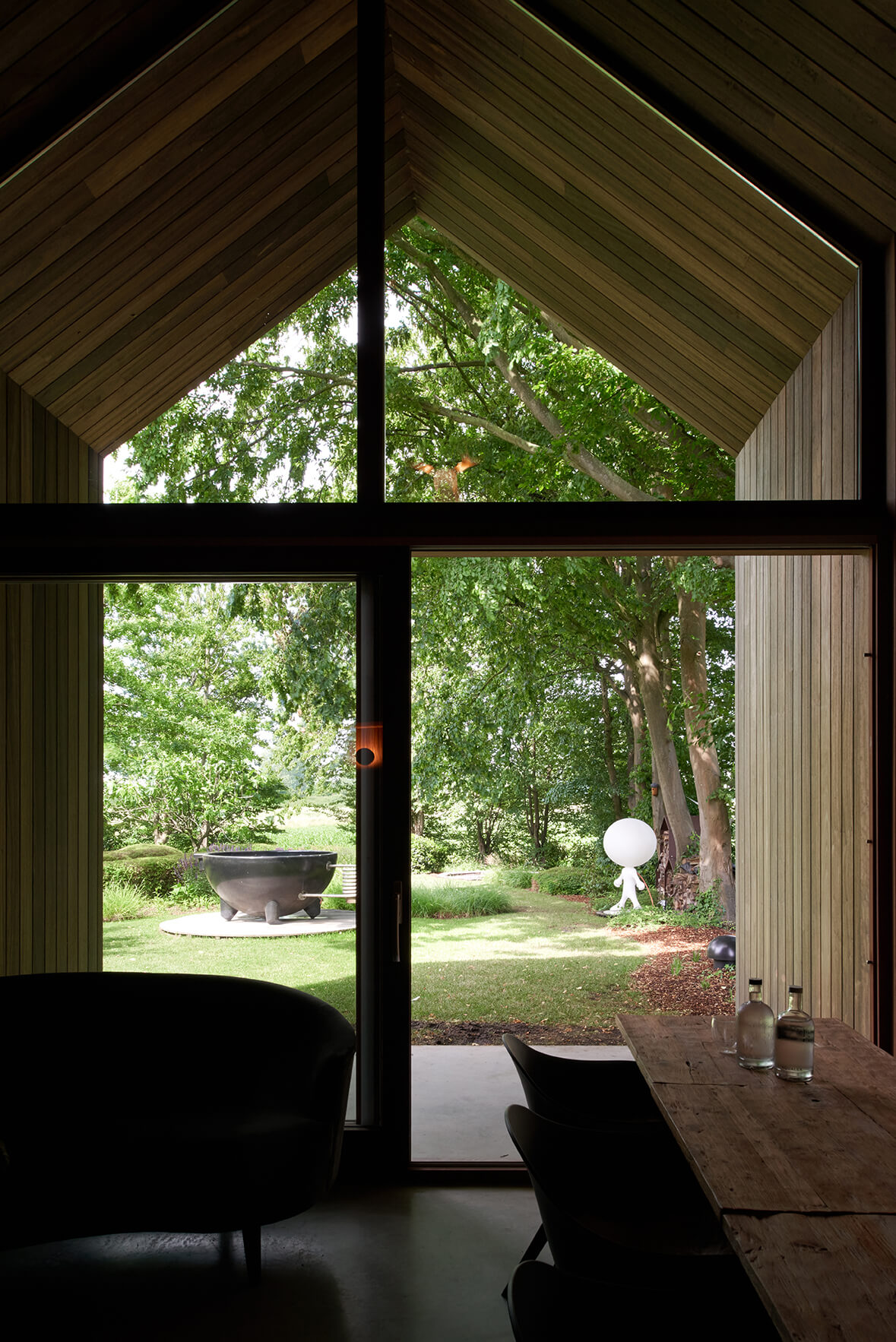 Binnenzijde van houten tiny house met inkomdeur en grote raampartijen.