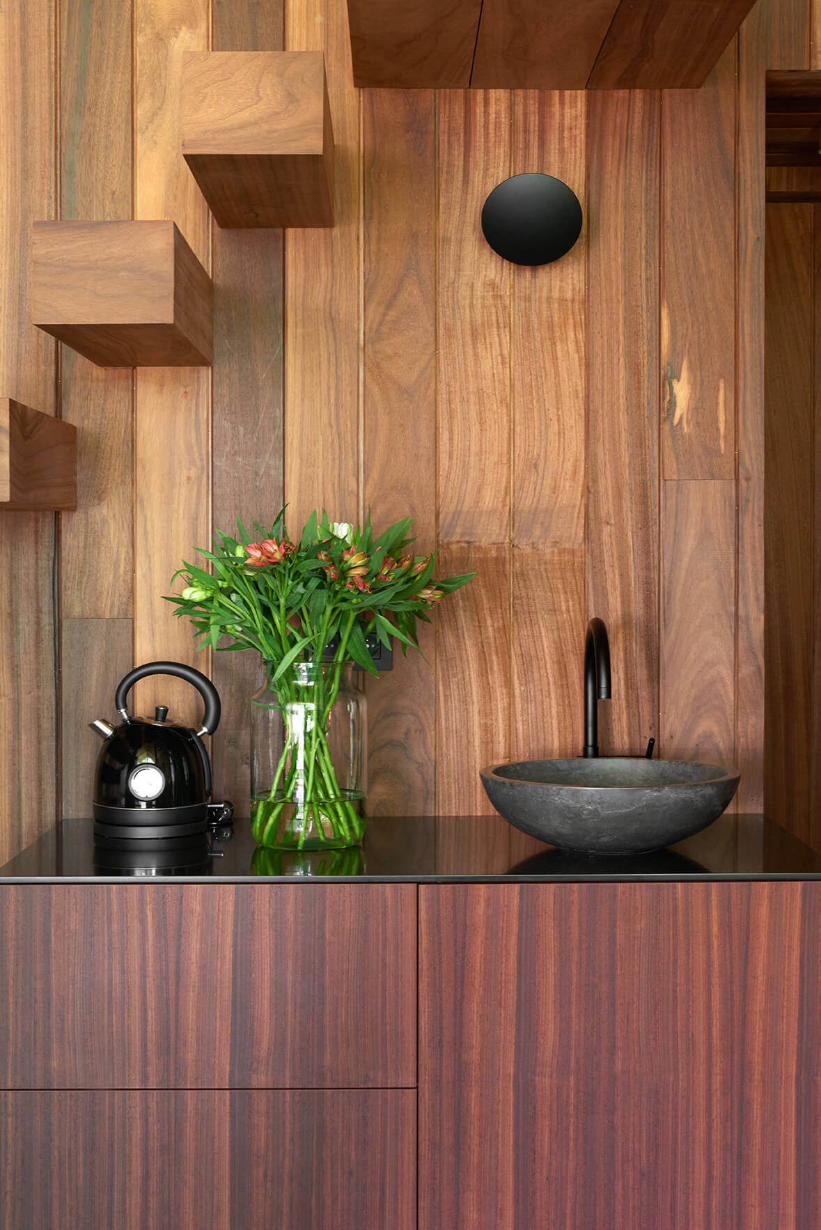 Keuken in houten tiny house met keukenblad en lavabo uit natuursteen.