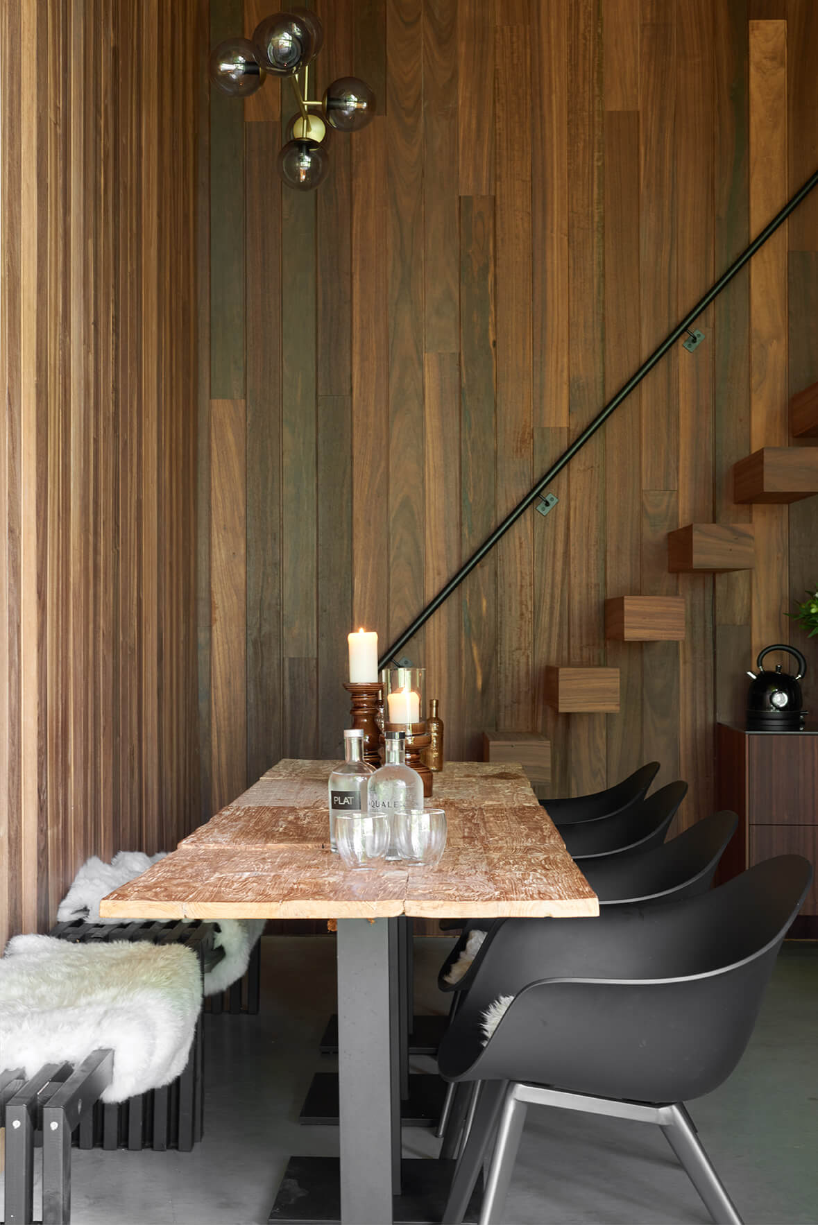 Interieur van tiny house uit houtskelet met eettafel, trap en houten binnenbekleding.