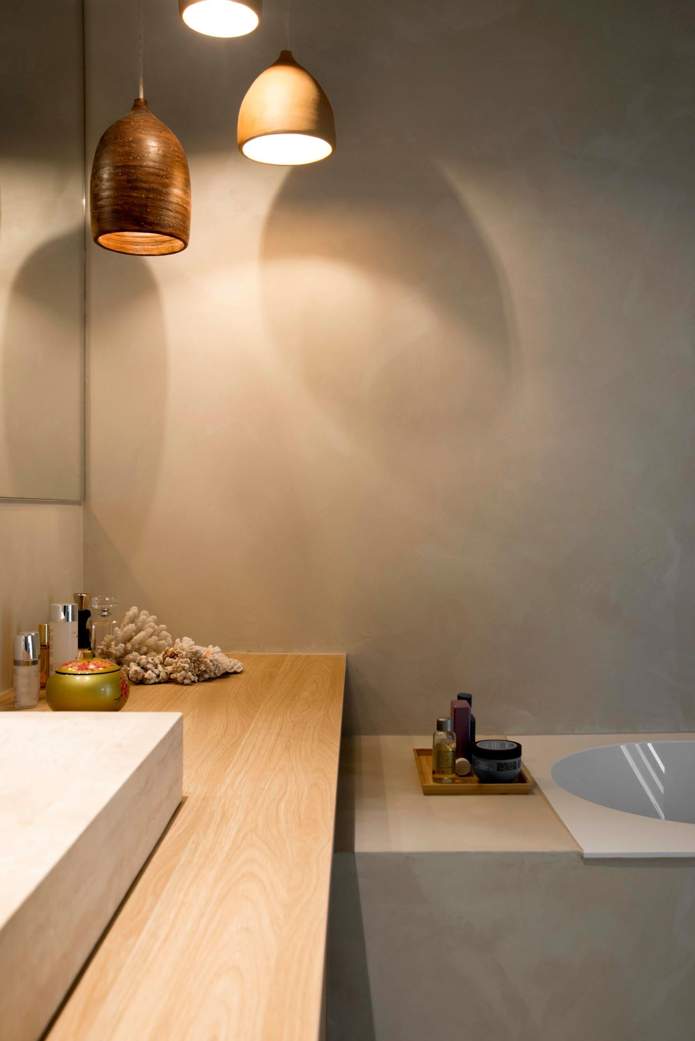 Moderne badkamerrenovatie met werkblad dat door loopt tot over het bad.