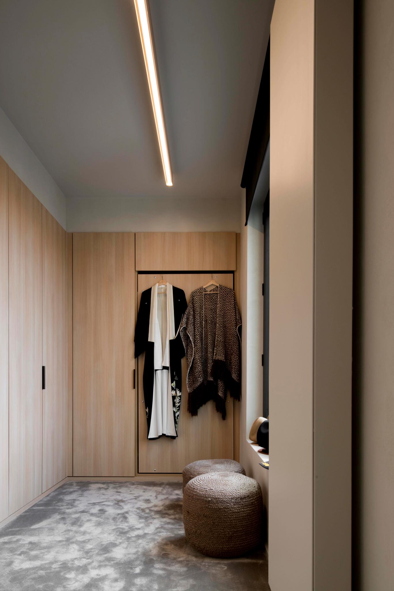 Dressing na totaalrenovatie met inbouwkasten uit hout.