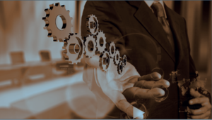 Geschäftsmann im Anzug hält digital schwebende Zahnräder, Symbol für Workflow und Prozessautomatisierung.