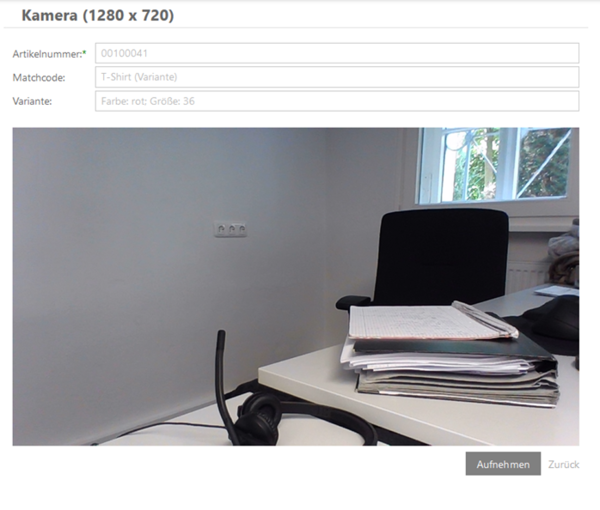 Büroszene mit Schreibtisch, gestapelten Ordnern, Notizblock, Headset und einem Fenster im Hintergrund.