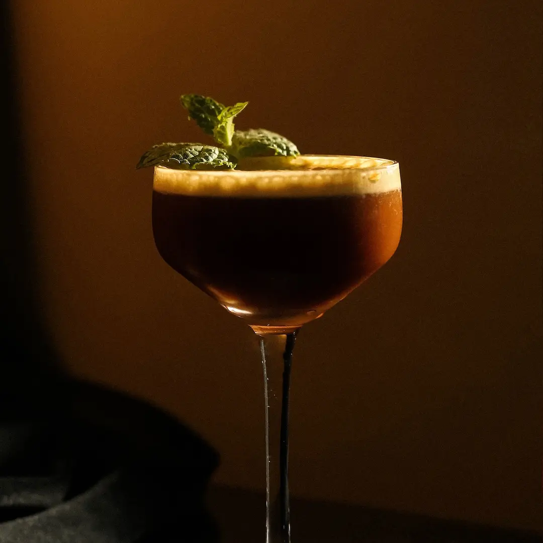 Non-alcoholic Amaro coffee cocktail on a dark brown background