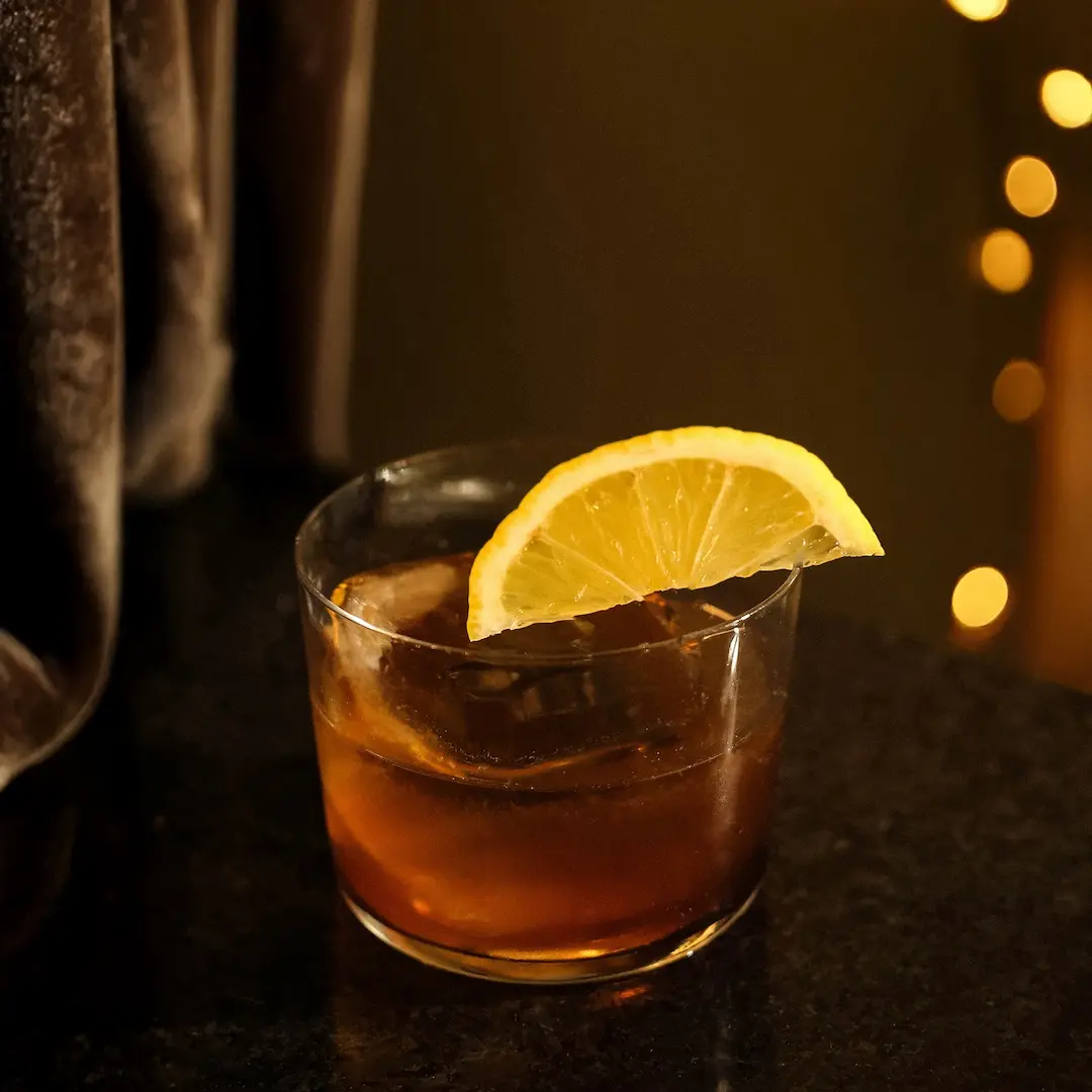 Non-alcoholic Amaretto lemon cocktail on a dark brown background