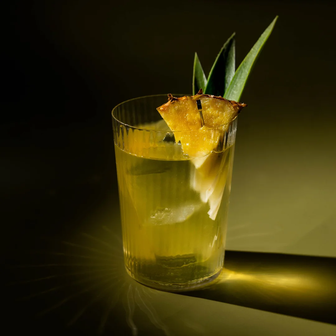 Non-alcoholic clarified Mai Tai cocktail on an olive background