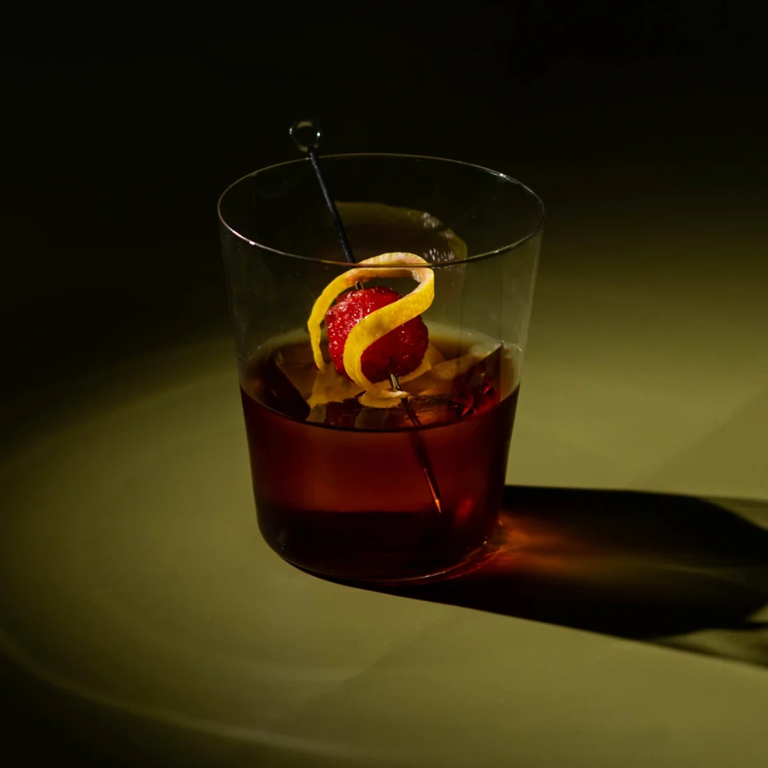 Non-alcoholic Raspberry Amaretto cocktail on an olive background.