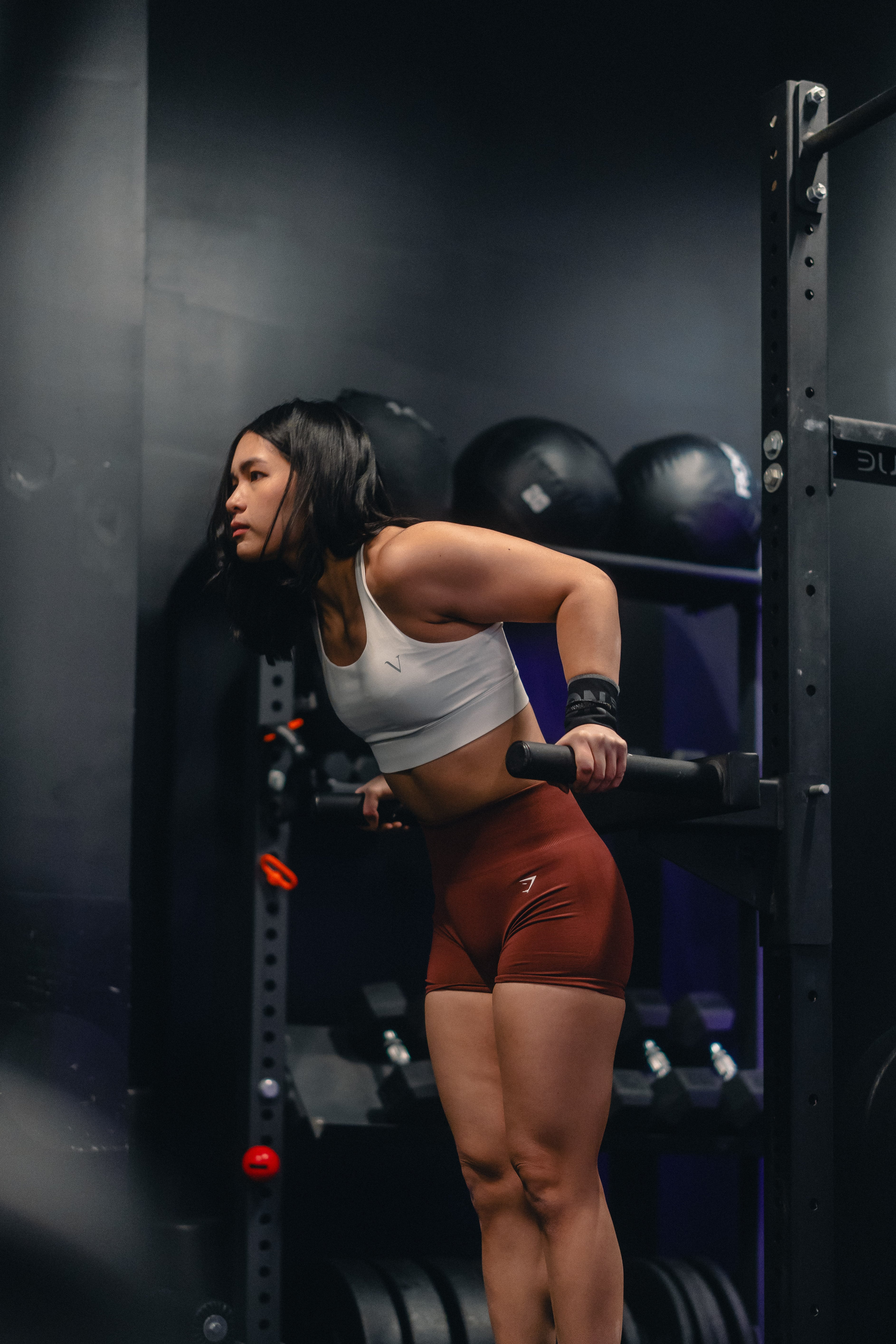 Issree performing tricep dips on parallel bars in a gym.