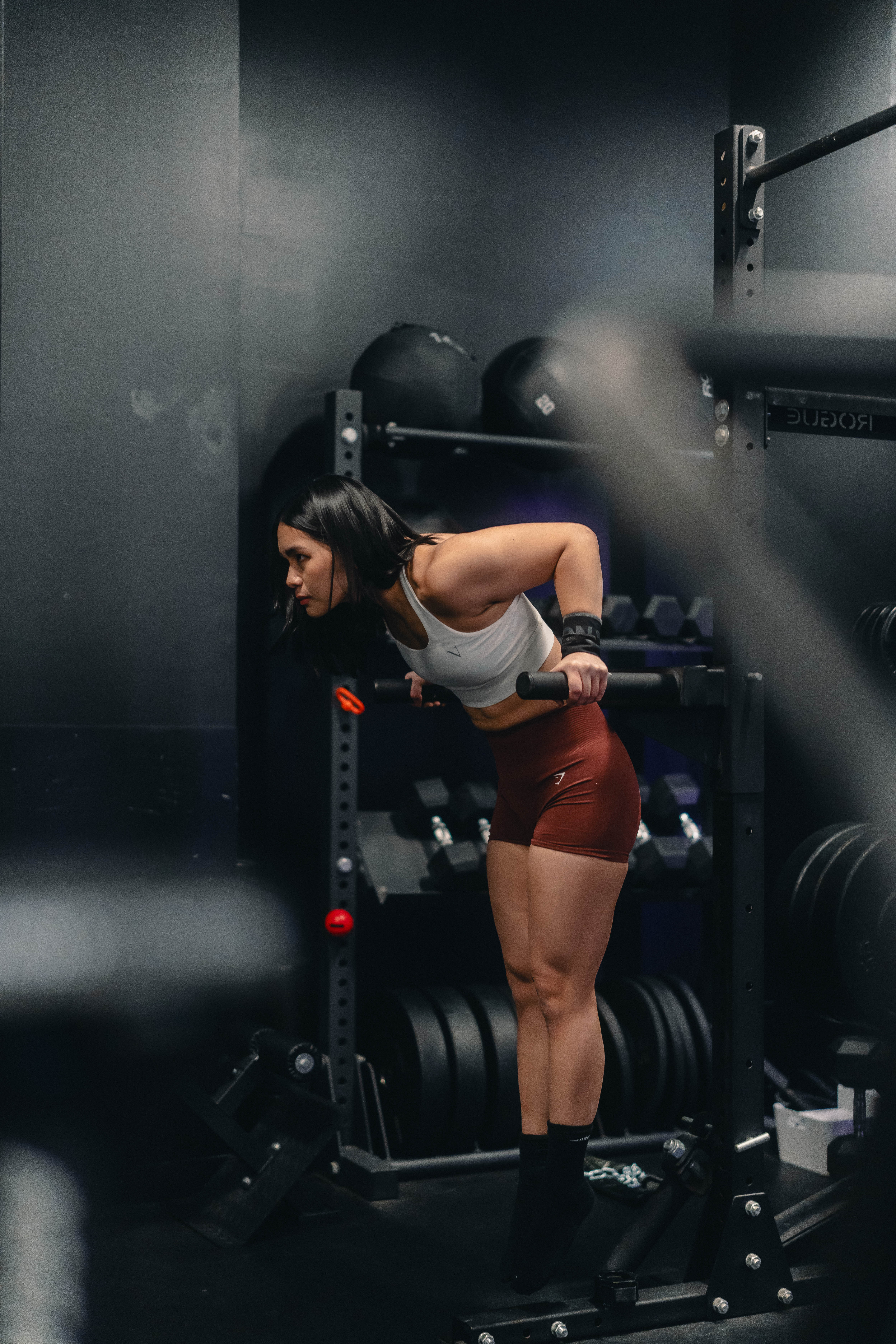 Athletic woman doing dips on parallel bars in a gym setting.