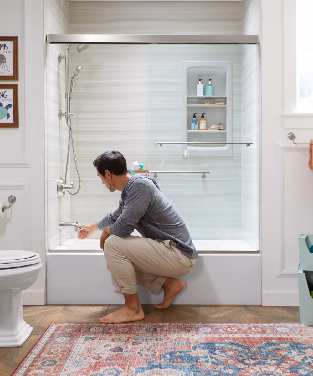 Beautifully remodeled Kohler shower with seamless glass doors and beautiful crushed stone walls.
