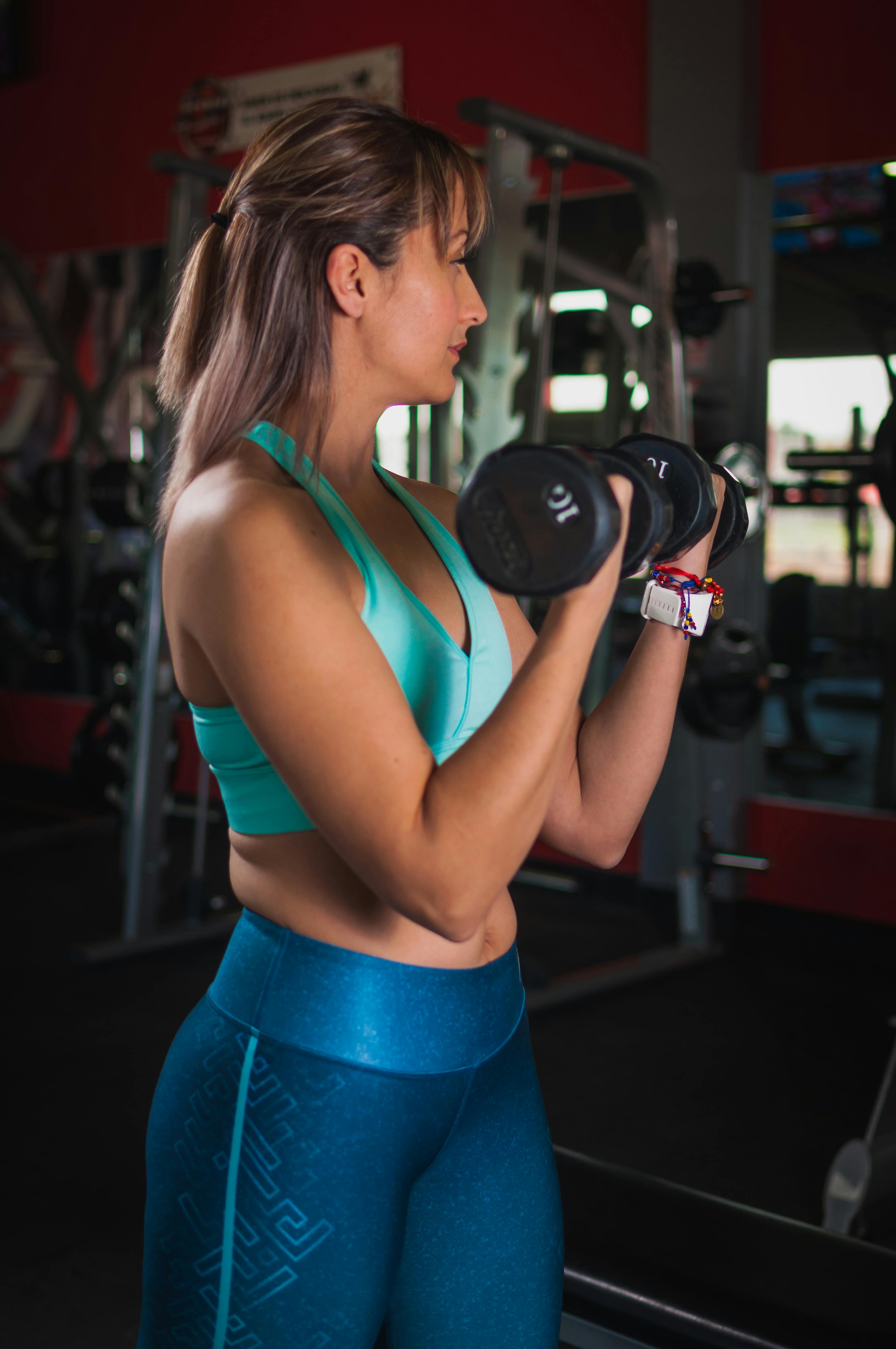 A fitness model with dumbells in both of her hands