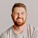 Headshot of Joshua McDonald, smiling against a light background.