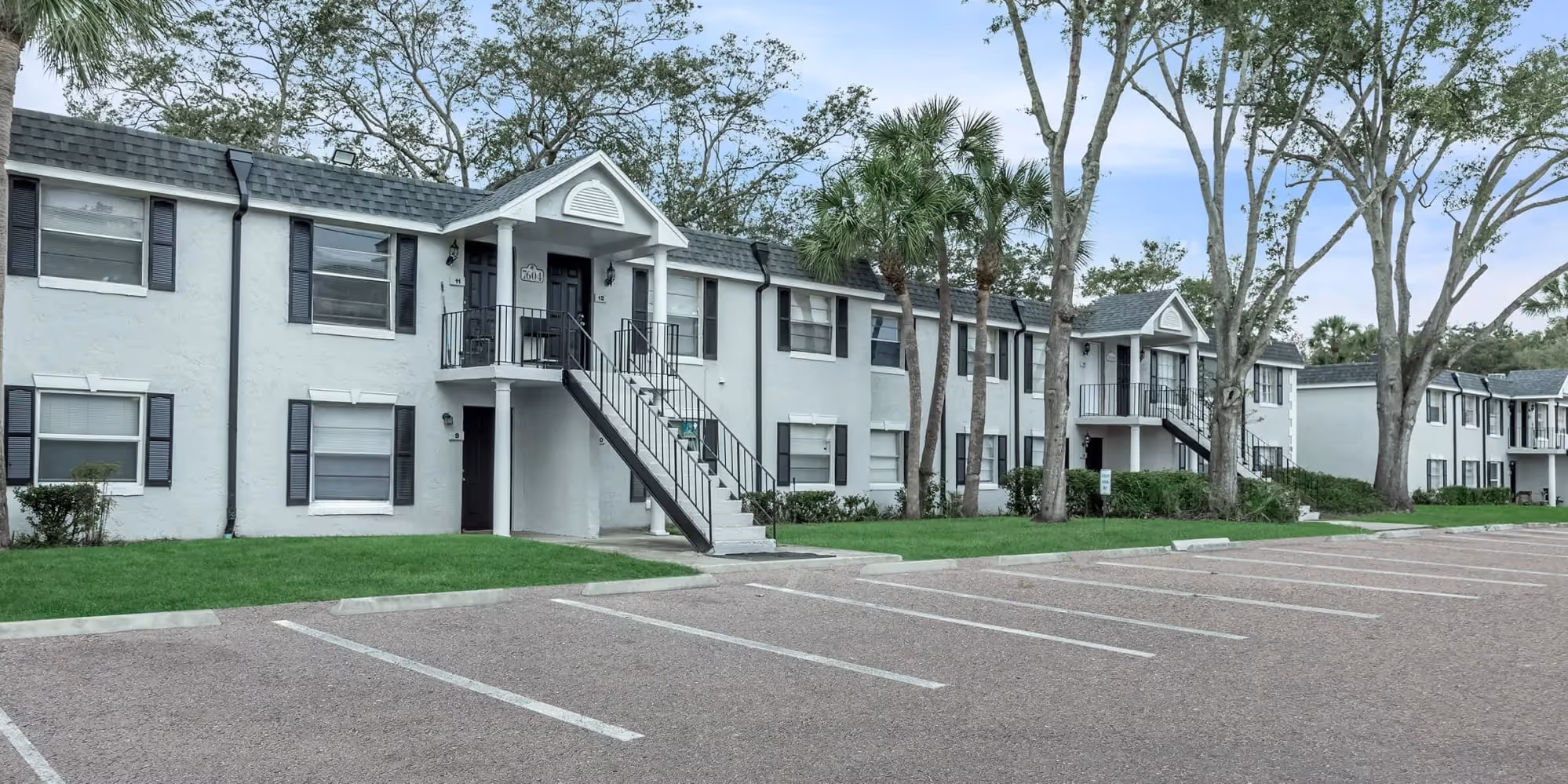 Melina exterior with greenery and view of paring lot