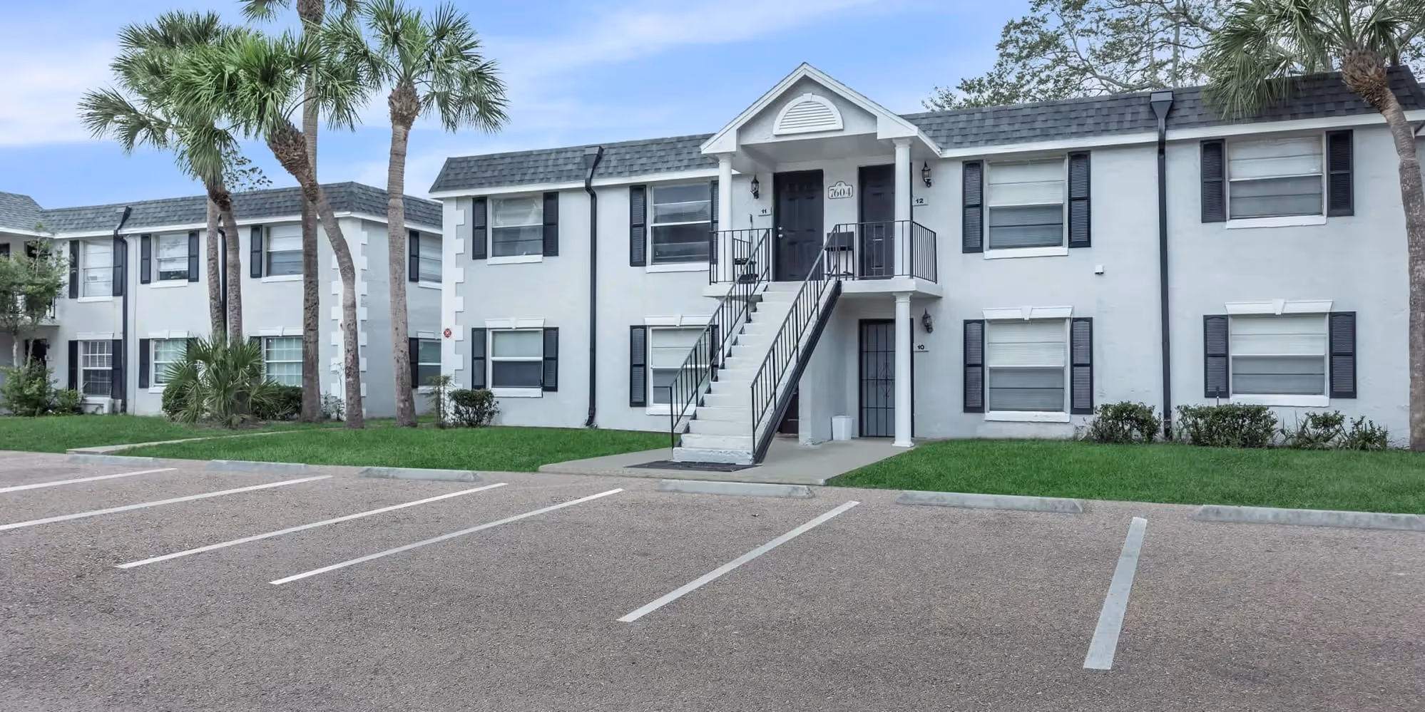 Melina exterior with greenery and view of paring lot