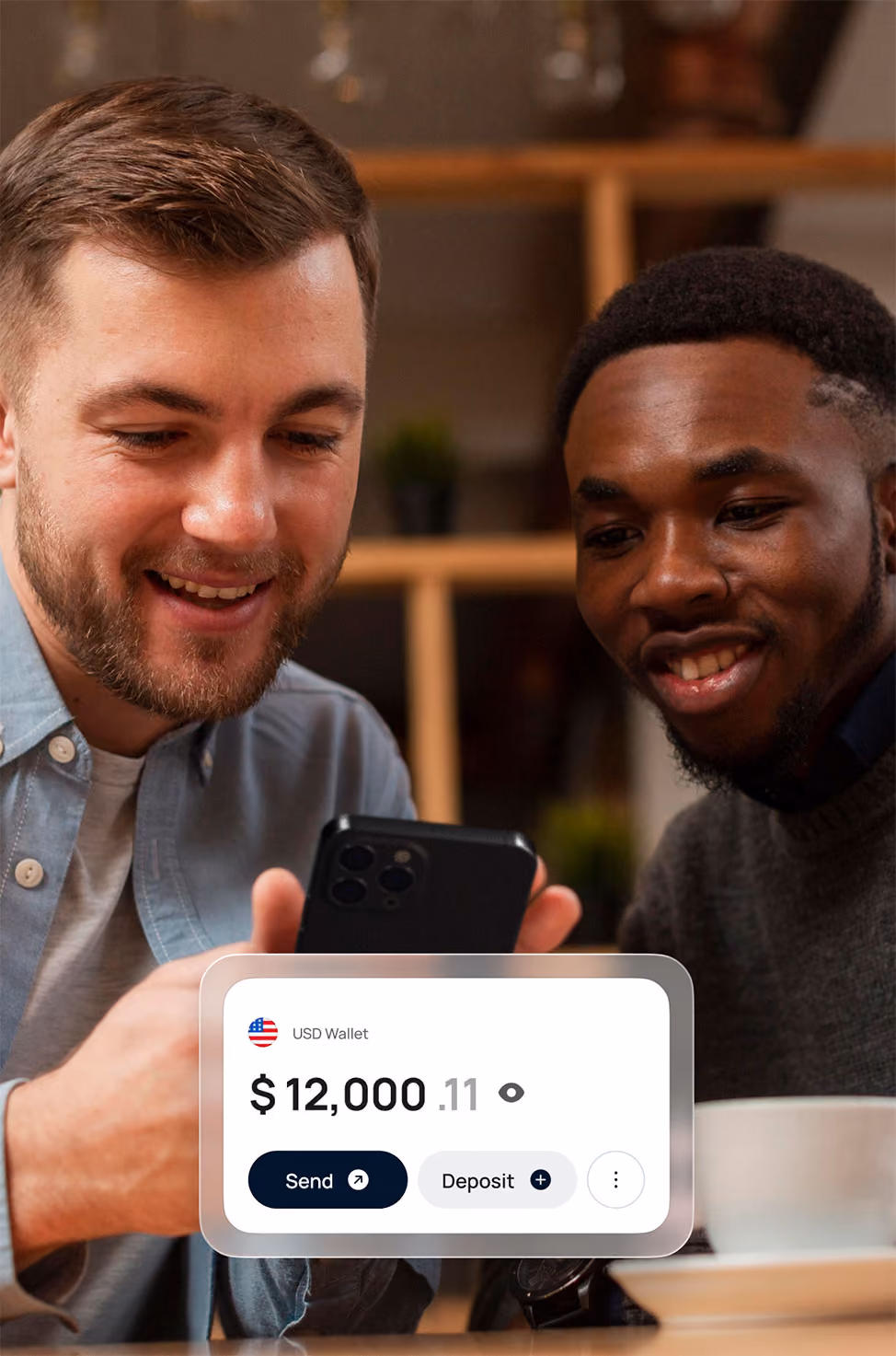 Two men smiling and looking at a smartphone together, with a digital wallet interface showing a balance of $12,000.11 and options to send or deposit money.