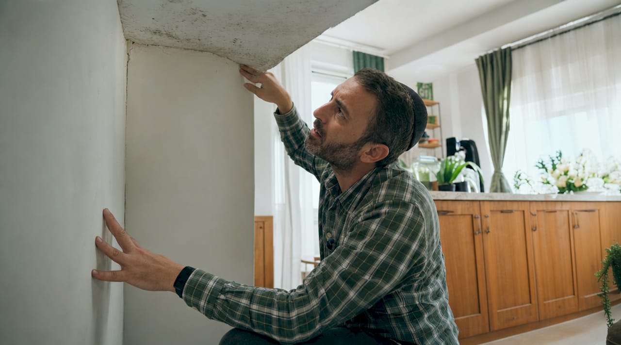 Man inspecting apartment for moisture damage