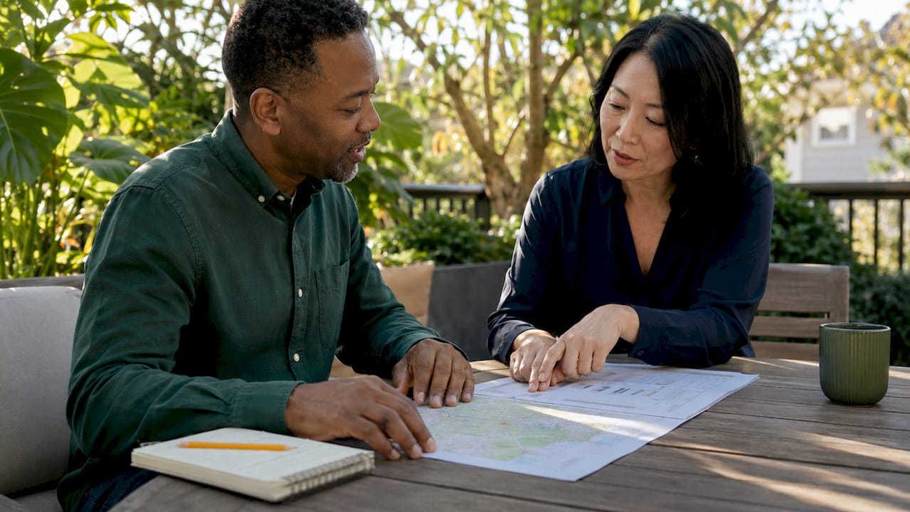 Two professionals discussing real estate market