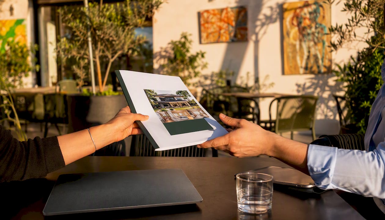 Hands exchanging real estate appraisal report