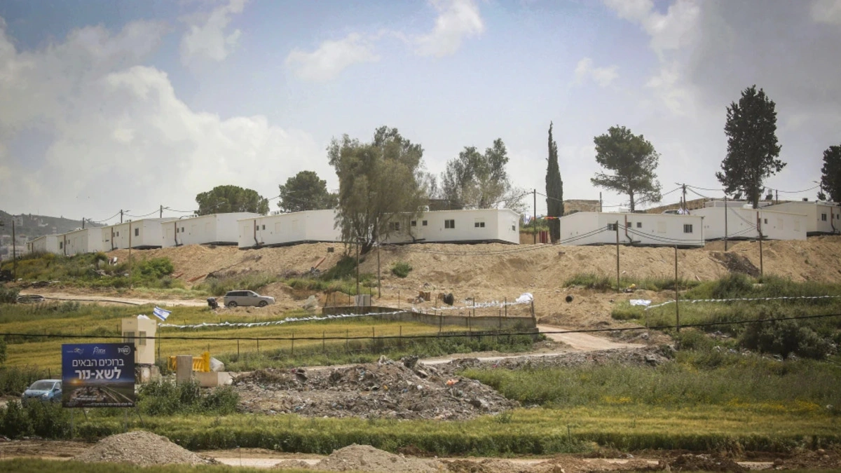 A wide view of the hillside site of Sa-Nur in Samaria with mobile homes and construction under a cloudy sky