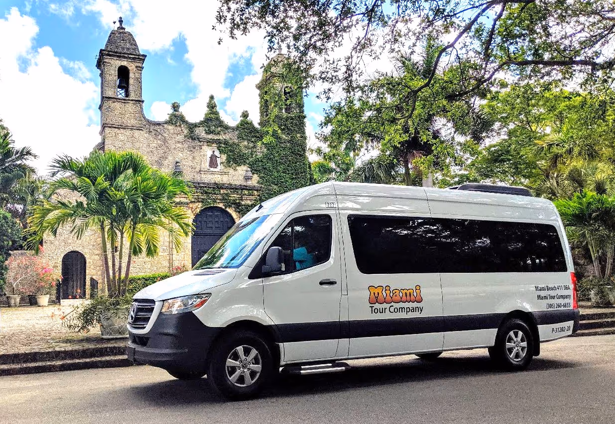 Airport shuttle van parking in Coconut Grove on a sunny day.
