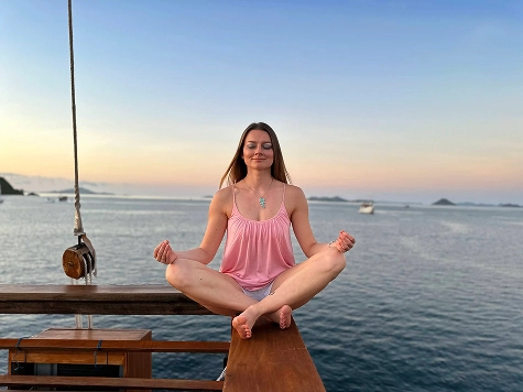 Tati meditating on the boat with sea view